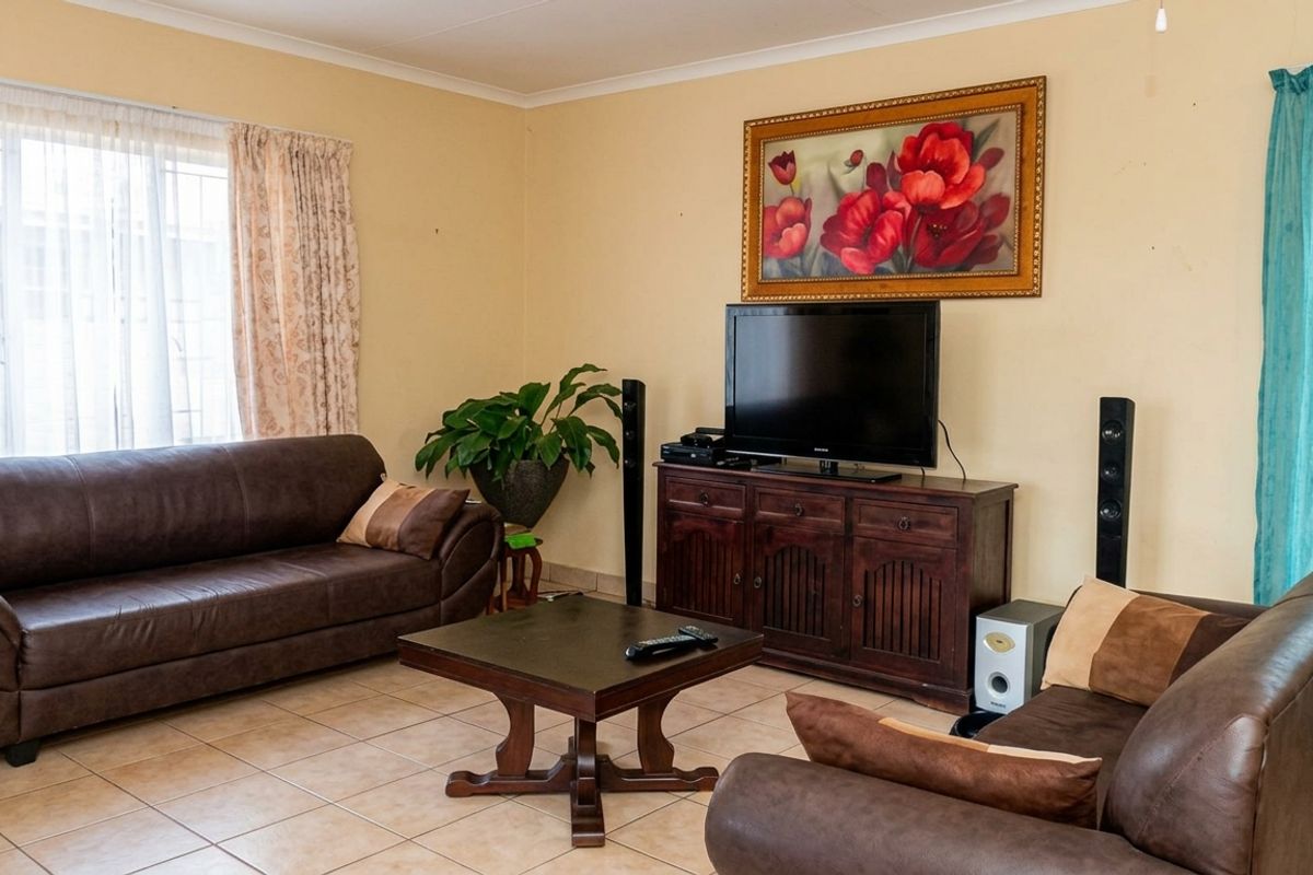 A comfortable living room featuring neutral wall tones and tiled flooring, providing a functional space for relaxation and entertainment.