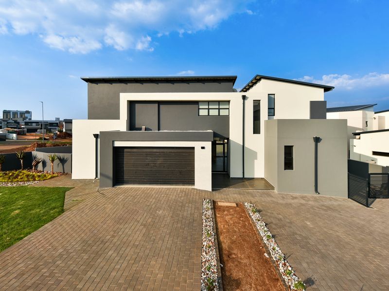 Modern double-storey residential home featuring a contemporary facade, paved driveway, and integrated double garage.
