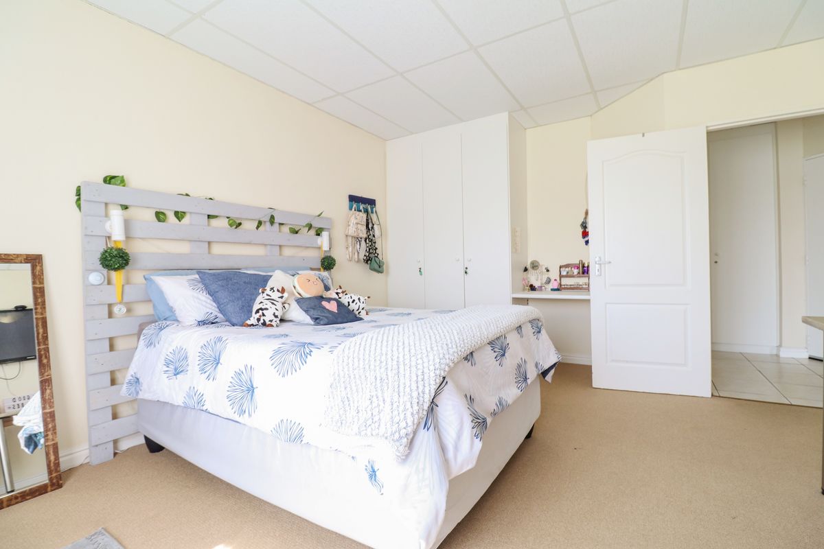 A bedroom featuring built-in cupboards, carpeted flooring, and a drop ceiling, offering a functional space with potential for modern updates.