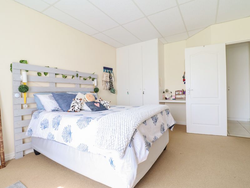 A bedroom featuring built-in cupboards, carpeted flooring, and a drop ceiling, offering a functional space with potential for modern updates.