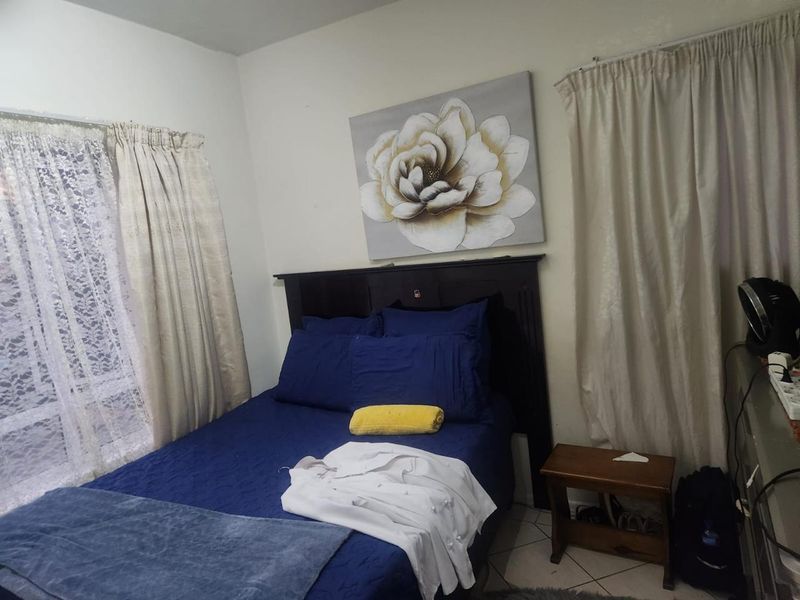 A standard bedroom featuring tiled flooring and neutral wall finishes, providing a functional space for rest.