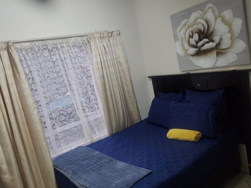 A standard bedroom featuring tiled flooring and a central ceiling light fixture, providing a functional living space.