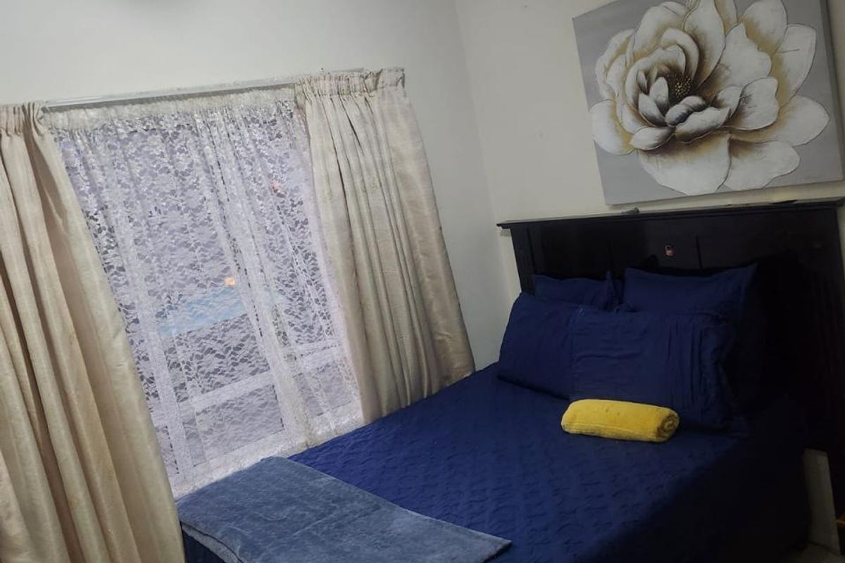 A standard bedroom featuring tiled flooring and a central ceiling light fixture, providing a functional living space.