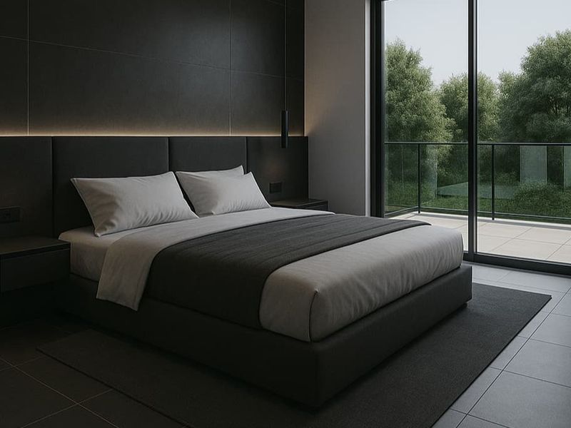 Modern bedroom featuring dark tiled flooring, integrated LED accent lighting, and large sliding glass doors opening onto a private balcony.