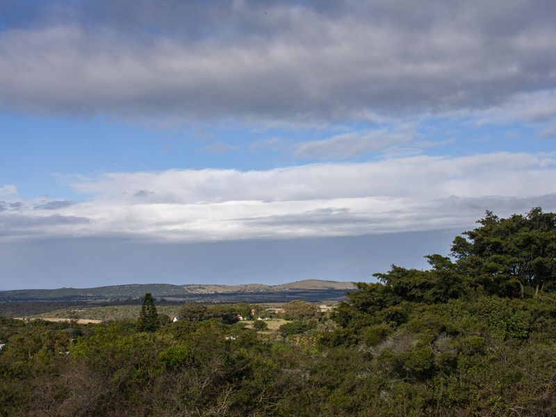 A scenic landscape view overlooking rolling hills and natural vegetation, showcasing the expansive rural surroundings of the property.
