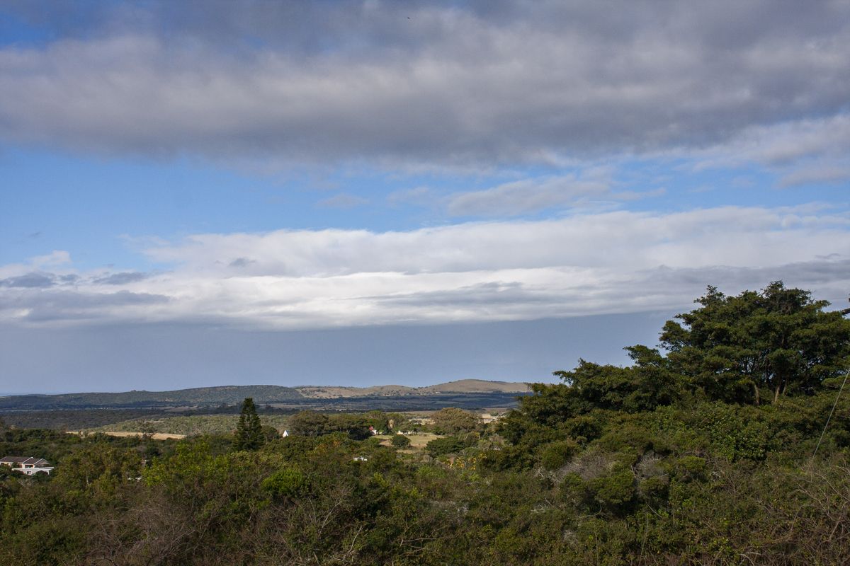 A scenic landscape view overlooking rolling hills and natural vegetation, showcasing the expansive rural surroundings of the property.