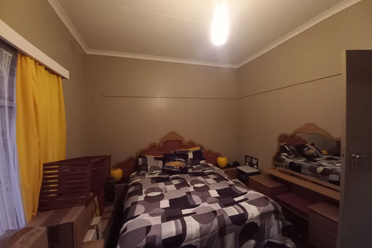 A standard bedroom featuring neutral wall paint, coving, and a picture rail, providing a functional space ready for cosmetic updates.