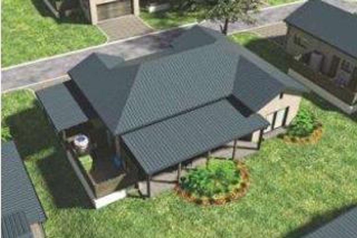 An aerial view of a townhouse featuring a metal roof, a covered patio area, and surrounding landscaped garden space.