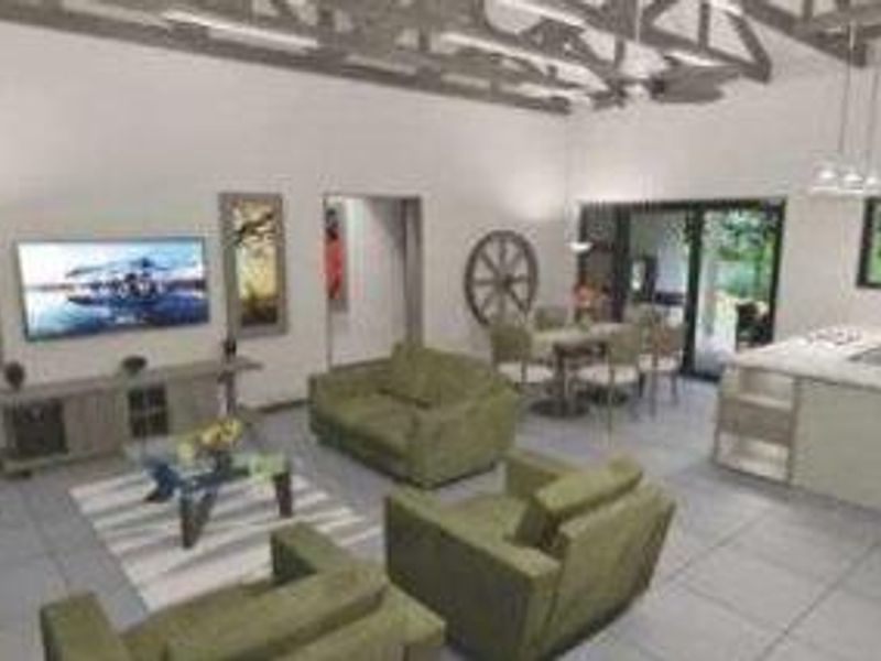Spacious open-plan living area featuring exposed roof trusses, tiled floors, and a modern kitchen island, seamlessly connecting to the outdoor patio through sliding doors.