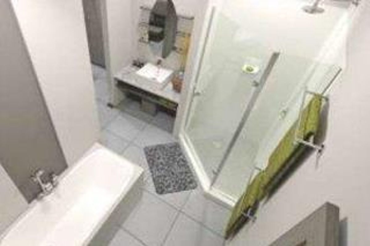 Modern bathroom featuring a built-in bathtub, separate shower enclosure, and a vanity basin with wall-mounted mirror.