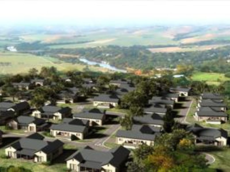 An aerial perspective of a residential townhouse estate development featuring multiple units with pitched roofs, set within a scenic landscape.