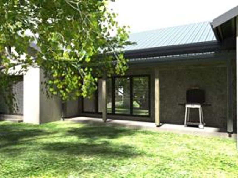 A covered patio area featuring a metal roof and large sliding glass doors, providing a seamless transition to the garden space.