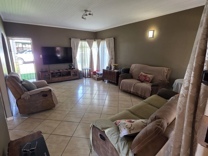 Spacious living room featuring tiled flooring, a tongue and groove ceiling, and a sliding glass door providing access to the exterior.