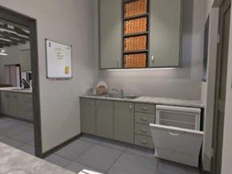 A functional scullery featuring built-in cabinetry, a stainless steel sink, and an integrated dishwasher, providing additional prep and wash-up space adjacent to the kitchen.