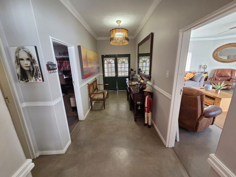 Welcoming entrance hall featuring polished concrete floors, decorative crown molding, and chair rail detailing, providing access to adjacent living areas.