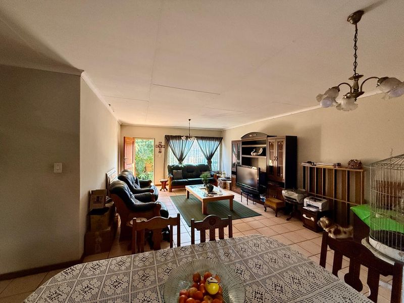 Open plan living and dining area featuring tiled flooring and direct access to the outdoor space through a sliding door.