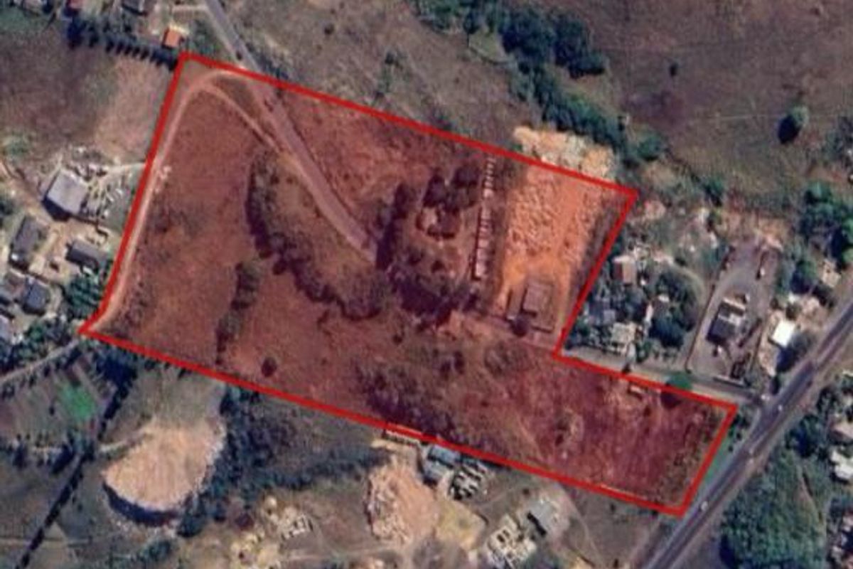 An aerial view of a large, undeveloped residential plot of land with clear boundary markings.