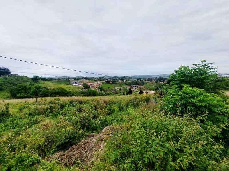 A wide-angle view of the vacant residential land, showcasing the surrounding landscape and natural vegetation.