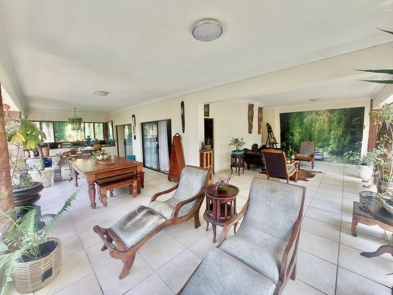 Spacious open-plan living and dining area featuring tiled flooring, large sliding glass doors, and integrated kitchen space, offering a versatile layout for modern living.