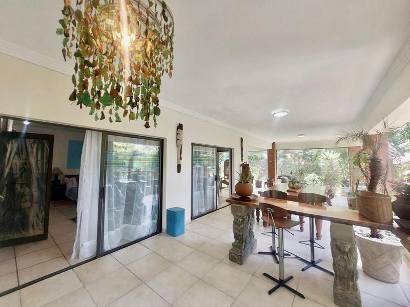 Spacious covered patio area featuring large sliding glass doors, tiled flooring, and recessed lighting, providing a seamless transition to the interior living spaces.