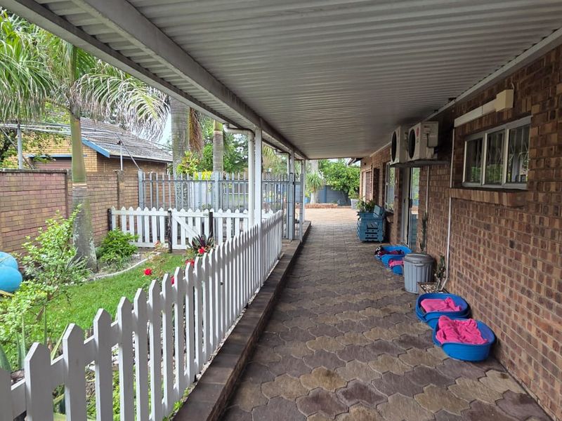 A covered outdoor patio area featuring brick wall construction, paved flooring, and direct access to the garden space.