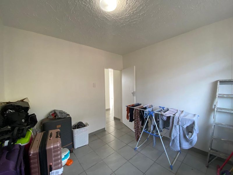 A functional utility space featuring tiled flooring and neutral walls, suitable for storage or laundry use.