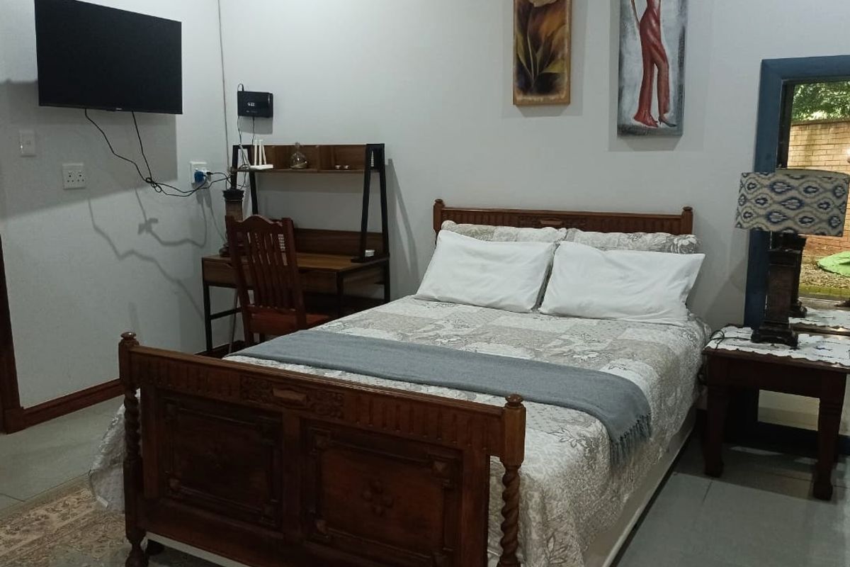 A functional bedroom featuring tiled flooring and a wall-mounted television, providing a comfortable and practical living space.