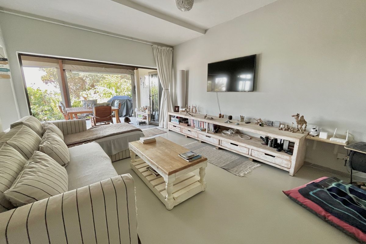 Spacious living room featuring polished concrete floors and large sliding glass doors that provide seamless access to the outdoor patio area.
