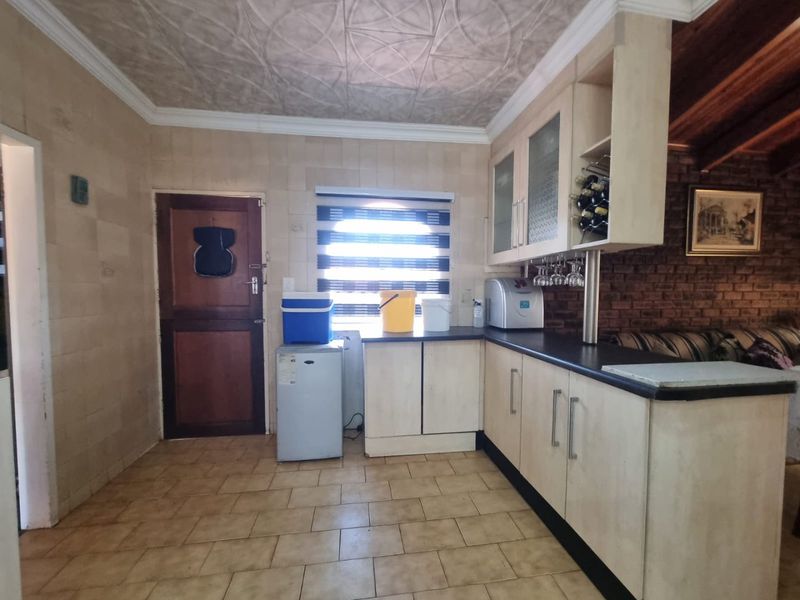 A functional kitchen area featuring built-in cabinetry, tiled surfaces, and decorative ceiling detailing, offering a practical layout for daily use.
