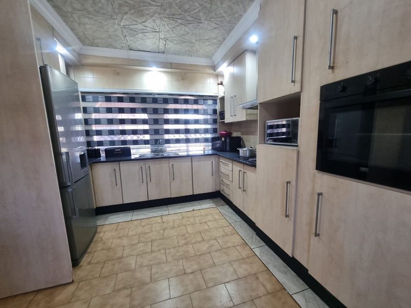 A functional kitchen featuring built-in cabinetry, integrated oven, and tiled flooring, offering a practical layout with ample storage space.