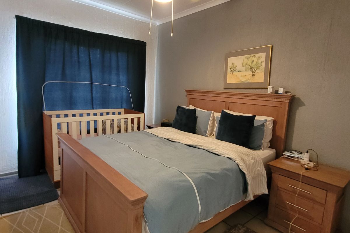 A functional bedroom featuring tiled flooring and a ceiling fan, providing a comfortable and practical living space.