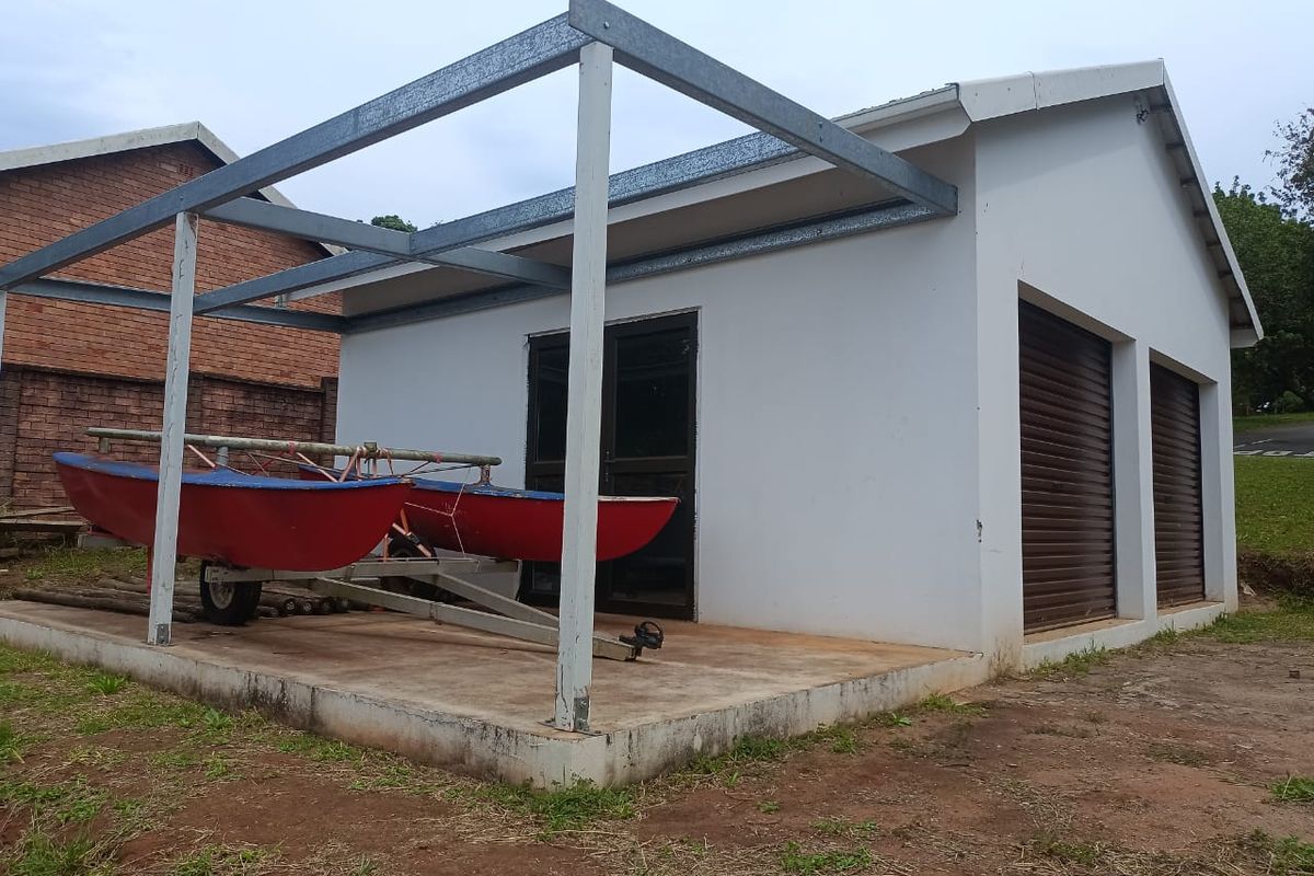 A detached garage structure featuring two roller shutter doors, a side glass sliding door, and an attached steel-framed pergola over a concrete slab.