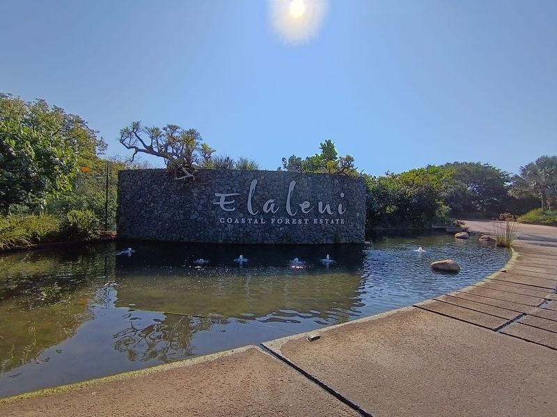 The entrance to Elaleni Coastal Forest Estate featuring a stone signage wall and a decorative water feature.