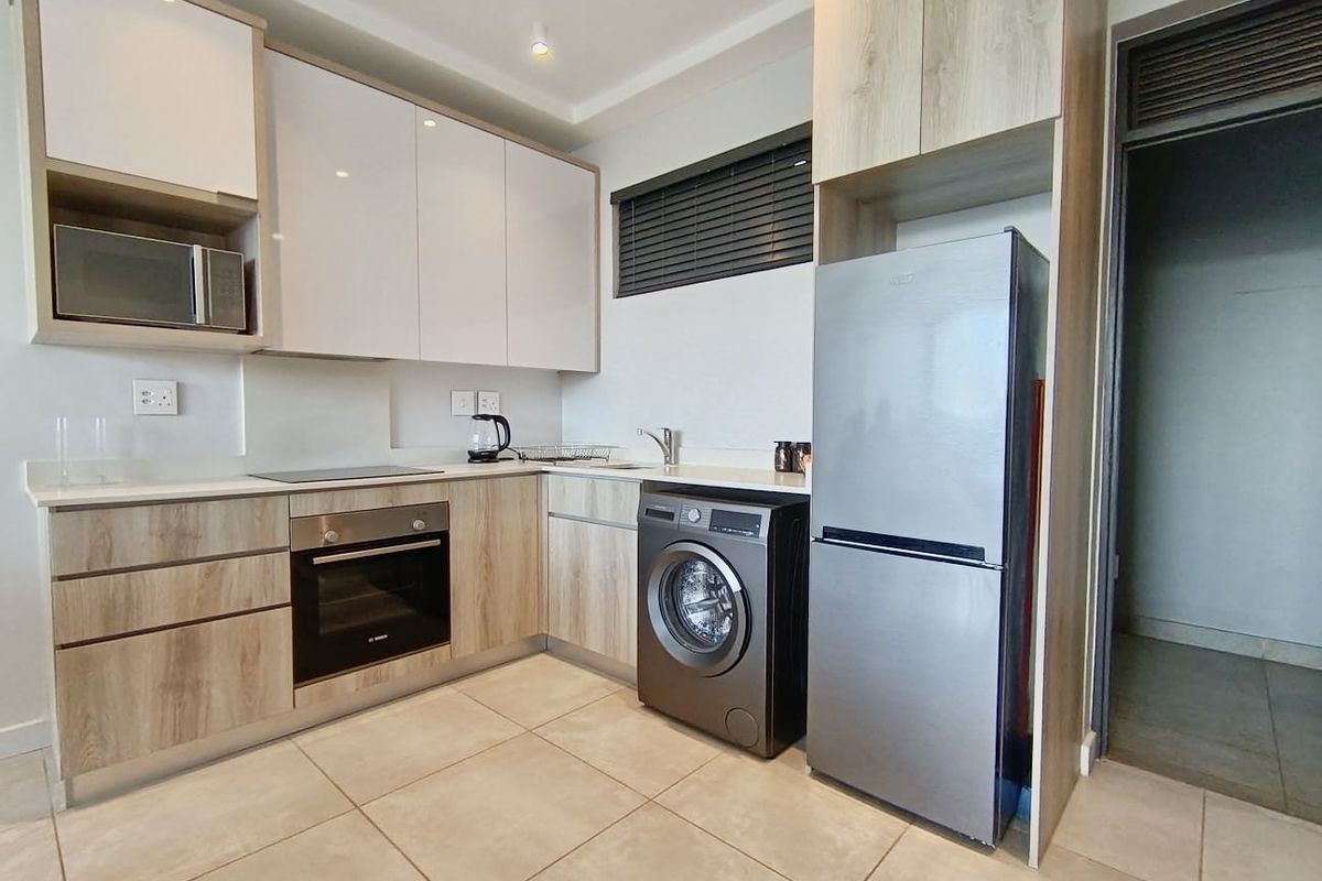 Modern kitchen featuring sleek cabinetry, stone countertops, integrated appliances, and tiled flooring, offering a clean and functional culinary space.