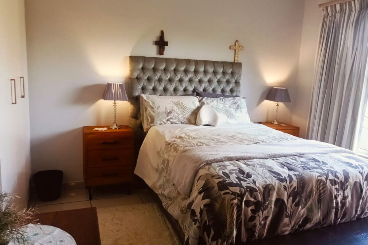 A well-maintained bedroom featuring tiled flooring and built-in cupboard storage, offering a comfortable and functional living space.