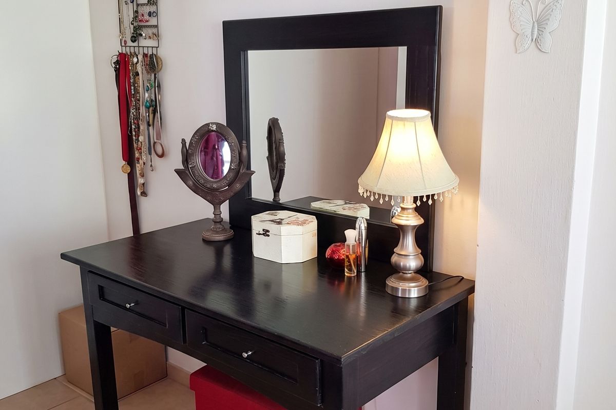 A bedroom corner featuring tiled flooring and a neutral wall finish.