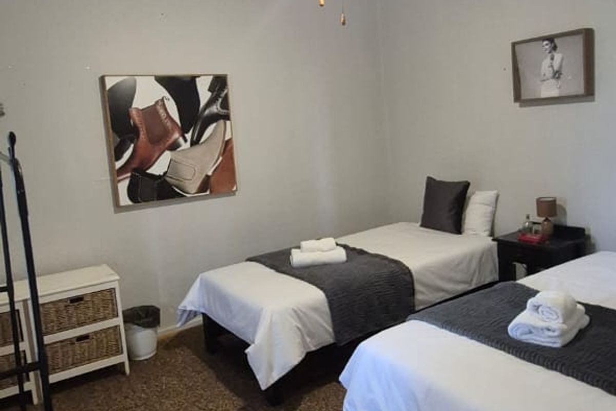 A bedroom featuring a ceiling fan and carpeted flooring, showing signs of wear and ceiling damage.