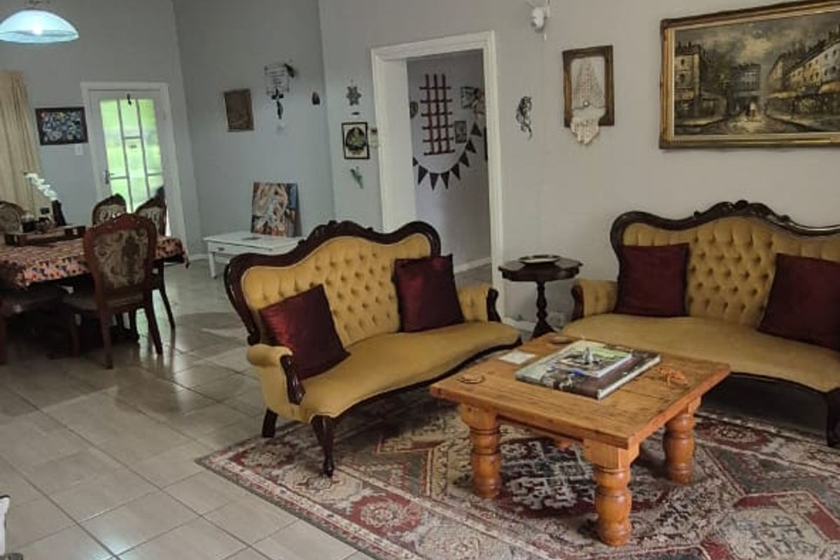 Spacious living area featuring neutral tiled flooring, ceiling fans, and classic pendant lighting, offering a comfortable and functional layout.