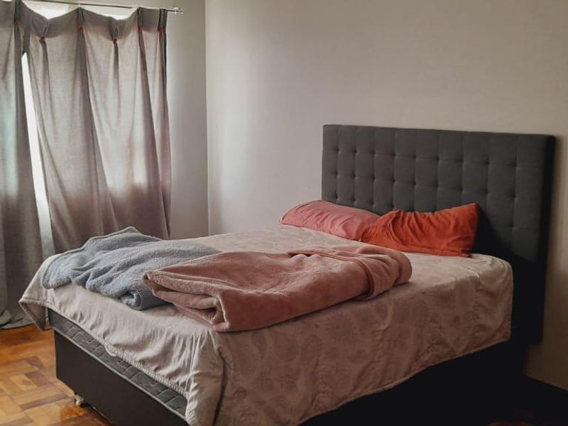 A bedroom featuring classic parquet flooring and neutral wall finishes, providing a functional space ready for personalization.