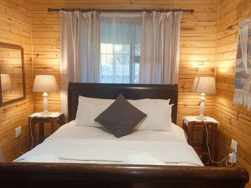 A cozy bedroom featuring warm timber wall cladding and a window with natural light, creating a rustic and inviting atmosphere.
