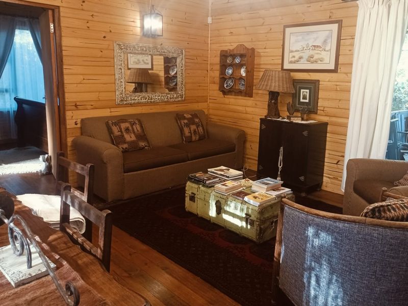 Cozy living room featuring warm timber wall cladding and natural wood flooring, creating a rustic cottage atmosphere.