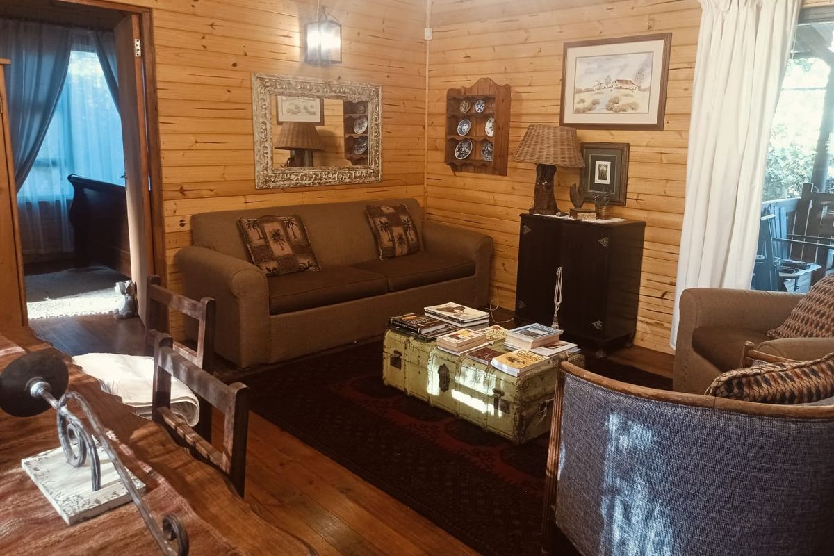 Cozy living room featuring warm timber wall cladding and natural wood flooring, creating a rustic cottage atmosphere.