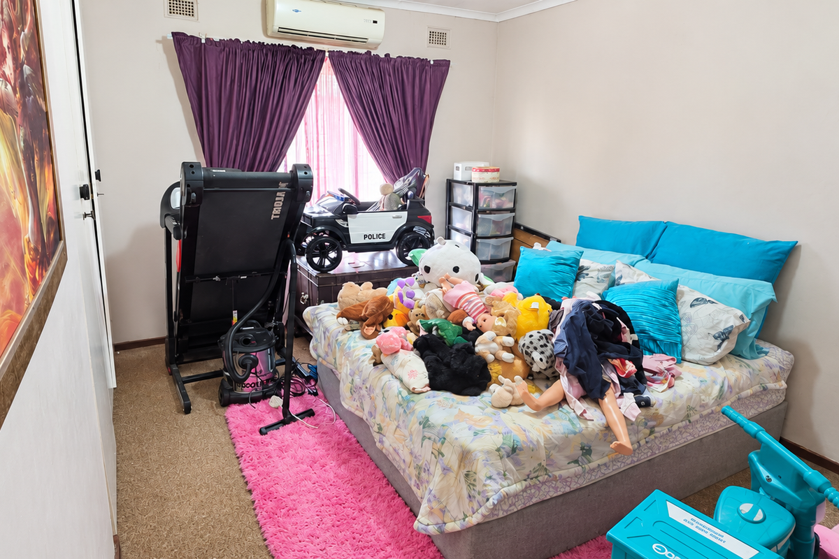 A bedroom featuring carpet flooring and a wall-mounted split-system air conditioner unit.