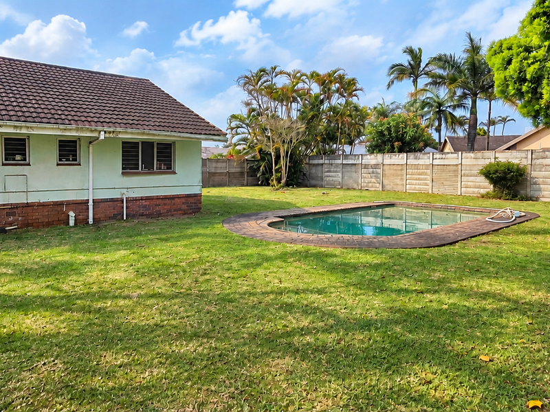 Spacious rear garden featuring a swimming pool with paved surround, established trees, and a perimeter boundary wall.
