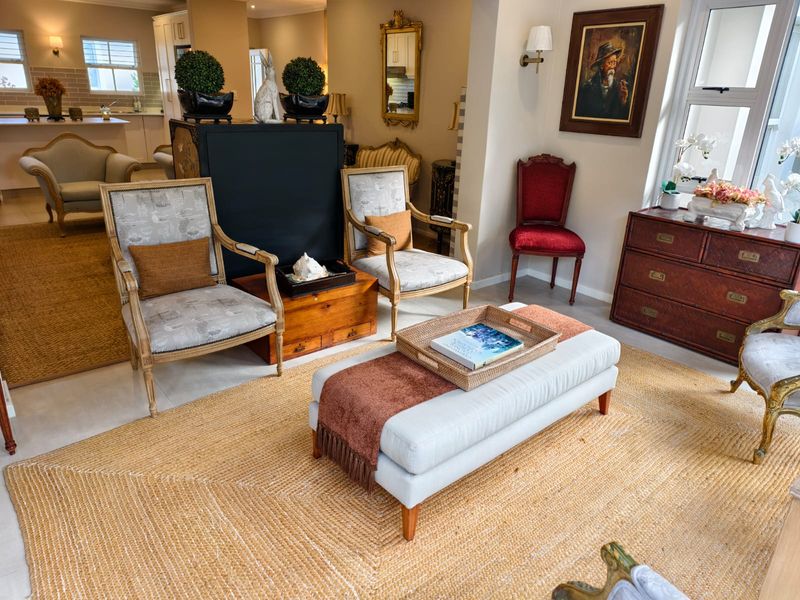 A spacious open-plan living area featuring tiled flooring, recessed lighting, and a well-appointed kitchen with cabinetry and a central island.