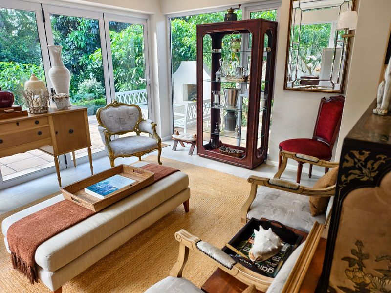 A bright and airy living room featuring large glass sliding doors that provide seamless access to the garden and patio area.