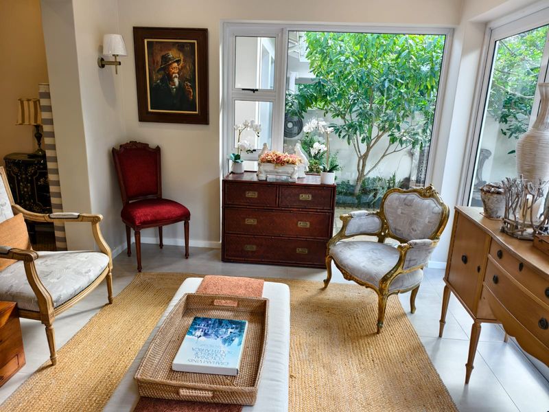 A bright and inviting living area featuring large glass sliding doors that provide ample natural light and a view of the lush garden.