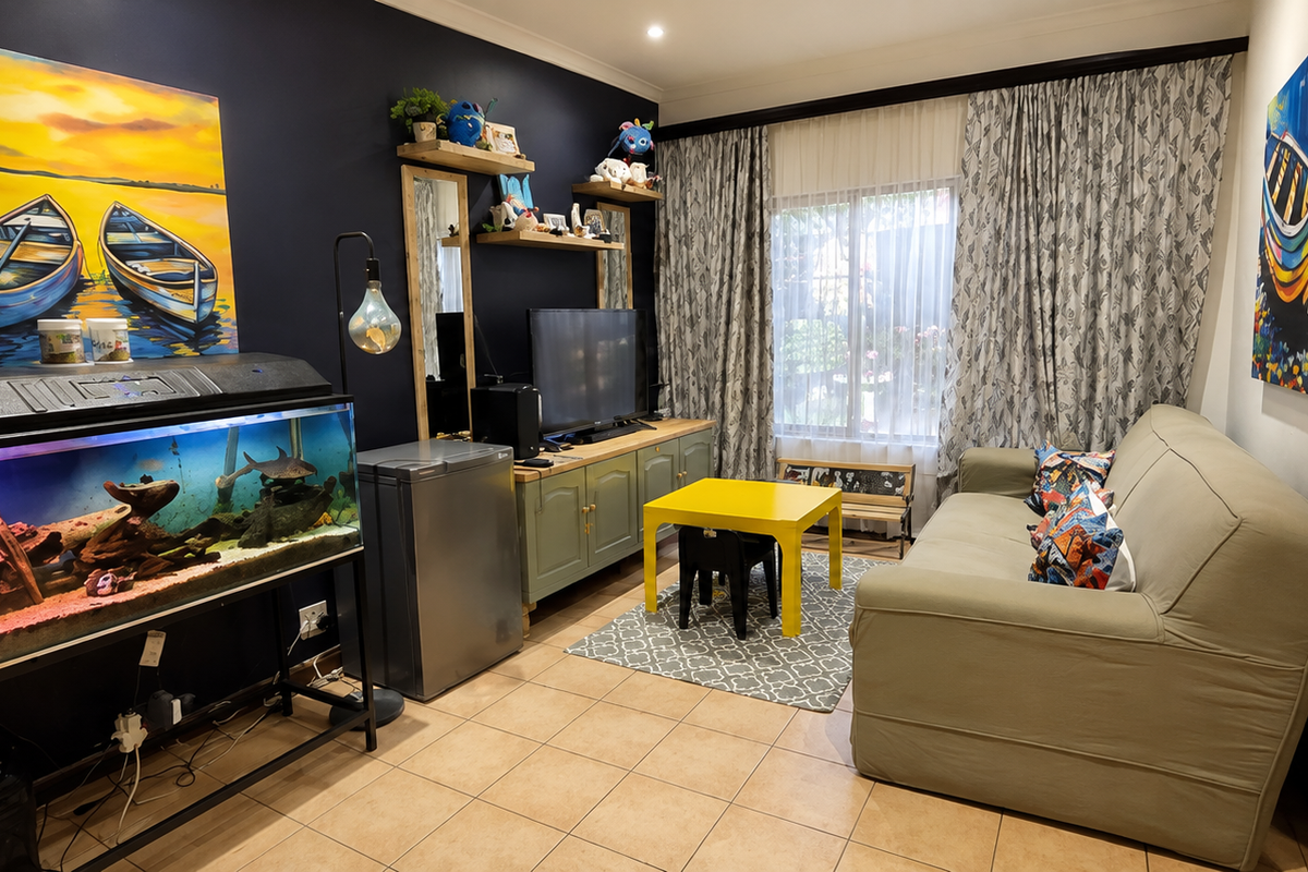 A cozy living room featuring tiled flooring, recessed lighting, and built-in cabinetry, offering a functional space with a unique glass block architectural detail.