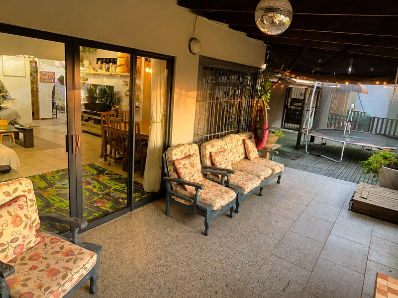 A covered outdoor patio area featuring tiled flooring and large sliding glass doors that provide seamless access to the interior living space.