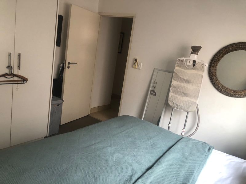 A functional bedroom featuring built-in wardrobe storage and neutral finishes, providing a practical space for rest.